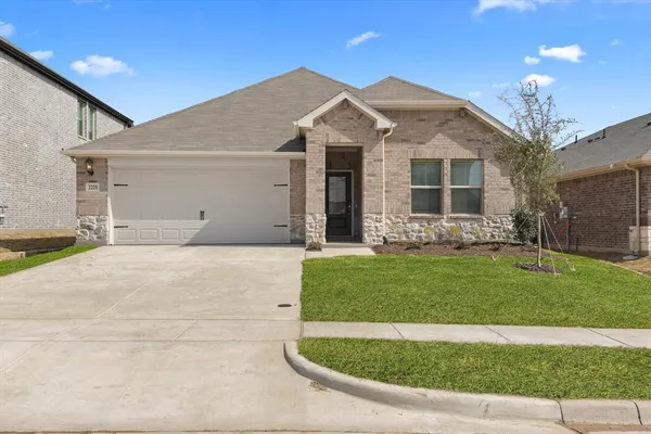 a front view of a house with a garden and yard