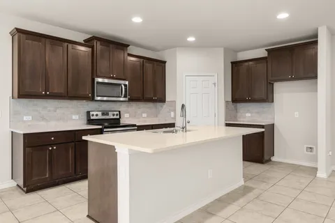 a kitchen with stainless steel appliances a refrigerator sink stove microwave and cabinets