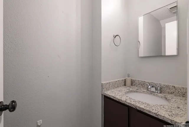 a bathroom with a granite countertop sink and mirror