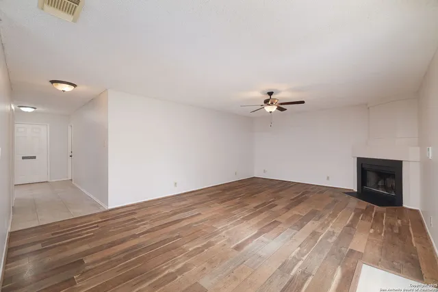 wooden floor in an empty room with a fireplace