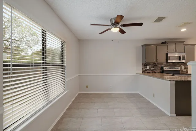 a kitchen with a refrigerator and white cabinets