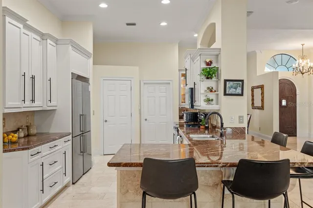 a kitchen with kitchen island granite countertop a sink cabinets and stainless steel appliances