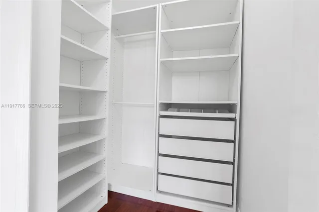 a view of walk in closet with empty racks