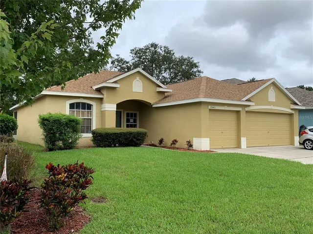 a front view of a house with a garden and yard