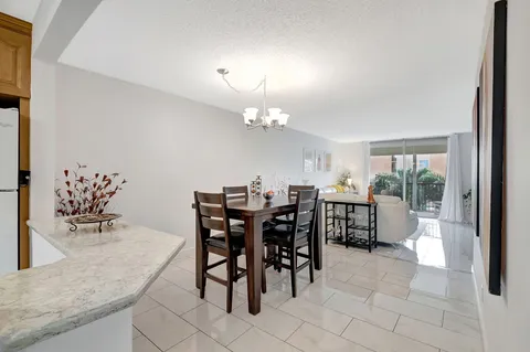a view of a dining room and kitchen with furniture and a chandelier