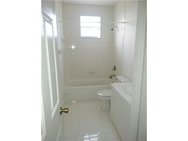 4103 Southwest 159th Avenue, Unit 49 Miramar, FL 33027 - Photo 16 of 20 a bathroom with a granite countertop toilet a sink and a mirror