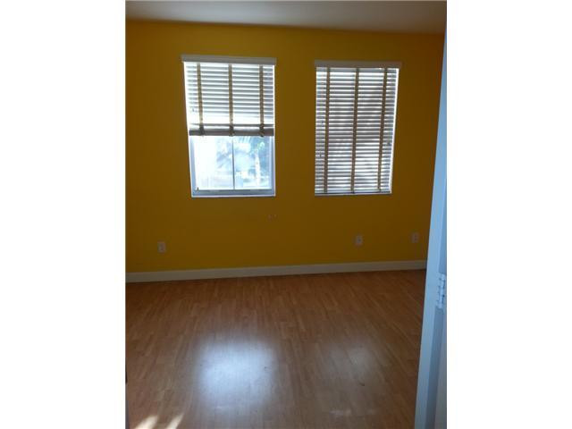 4103 Southwest 159th Avenue, Unit 49 Miramar, FL 33027 - Photo 18 of 20 a view of an empty room with wooden floor and a window