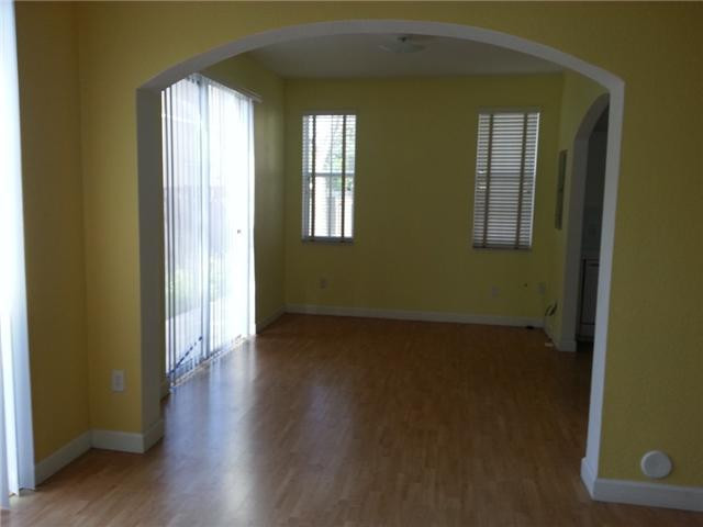 4103 Southwest 159th Avenue, Unit 49 Miramar, FL 33027 - Photo 7 of 20 an empty room with wooden floor and windows