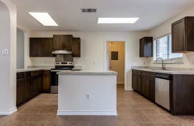 a kitchen with a sink stove and refrigerator