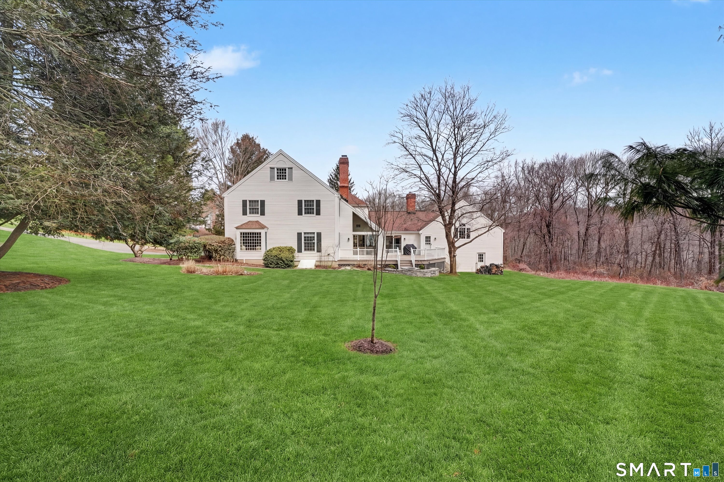 78 Keelers Ridge Road Wilton, CT 06897 - Photo 30 of 40 a view of a white house that has a small yard and large trees
