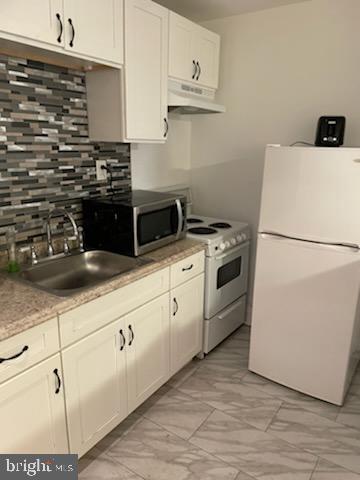 2053 South Cecil Street, Unit 1 Philadelphia, PA 19143 - Photo 4 of 13 a kitchen with stainless steel appliances granite countertop a sink a stove a refrigerator a white counter space and cabinets