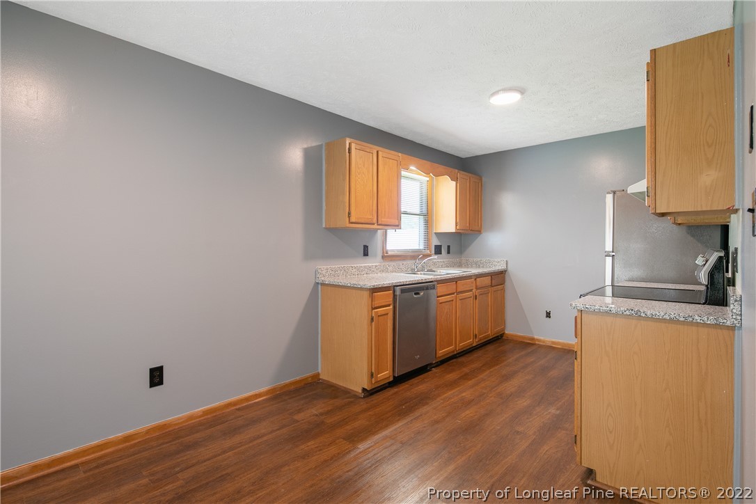 6405 Rhemish Drive Fayetteville, NC 28304 - Photo 6 of 21 a kitchen with a sink cabinets wooden floor and a window