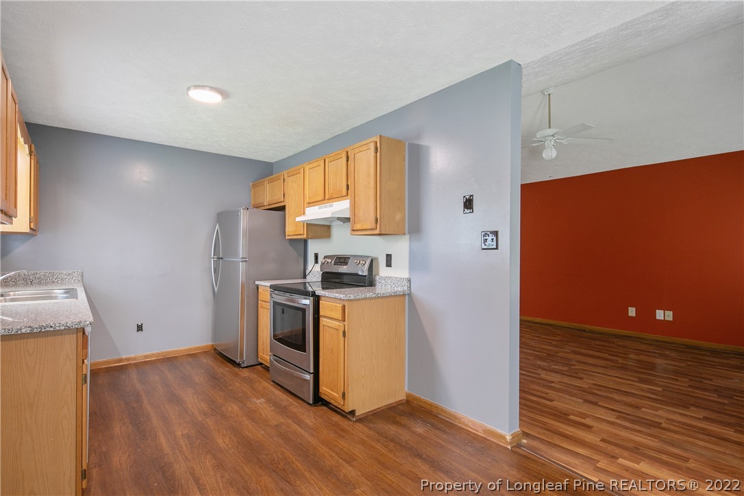 6405 Rhemish Drive Fayetteville, NC 28304 - Photo 7 of 21 a kitchen with a refrigerator and a stove top oven