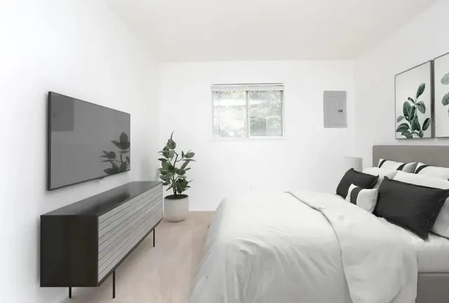 a bedroom with a large bed and a potted plant