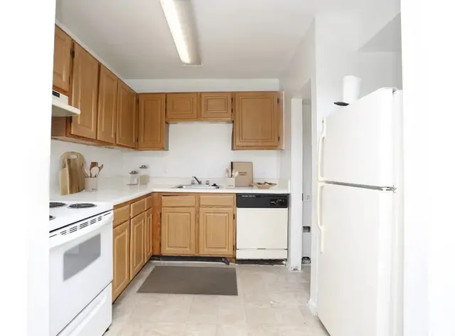 a kitchen with white cabinets and white appliances