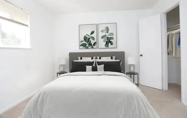 a bedroom with a bed and a painting on the wall