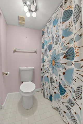 a bathroom with a toilet and a shower curtain