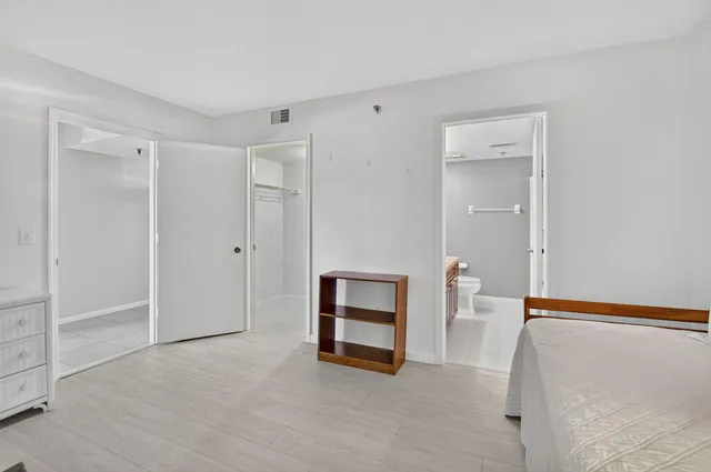 a view of an empty room with window and cabinet