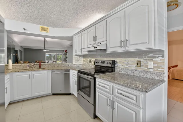 a kitchen with stainless steel appliances granite countertop a sink stove and cabinets