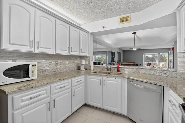 a kitchen with white cabinets and white appliances