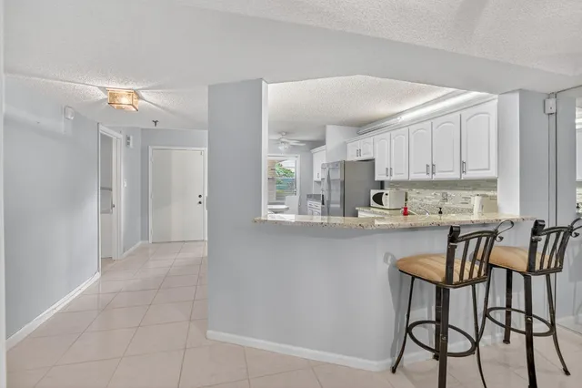 a kitchen with stainless steel appliances a table and chairs in it