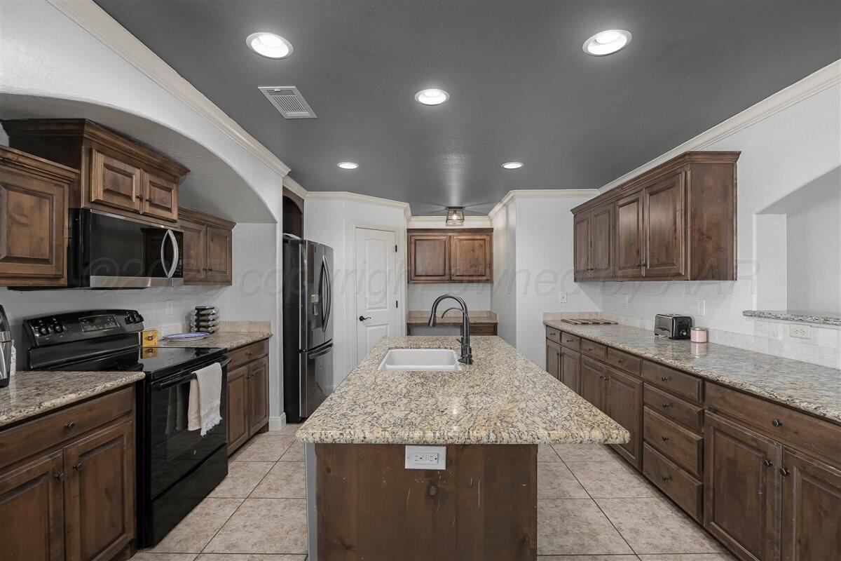 22 Sandra Lane Canyon, TX 79015 - Photo 11 of 25 a kitchen with stainless steel appliances granite countertop granite counter tops refrigerator a stove top oven and granite countertops