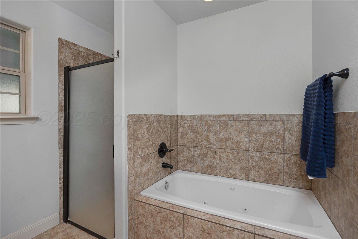 22 Sandra Lane Canyon, TX 79015 - Photo 18 of 25 a bathroom with a bathtub and a shower