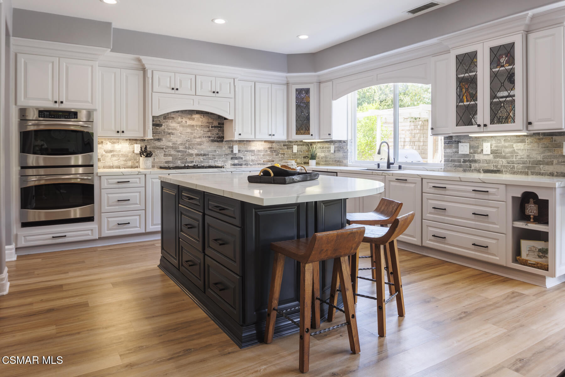 5859 Evening Sky Drive Simi Valley, CA 93063 - Photo 1 of 50 a kitchen with stainless steel appliances a stove top oven a sink dishwasher and a dining table with wooden floor