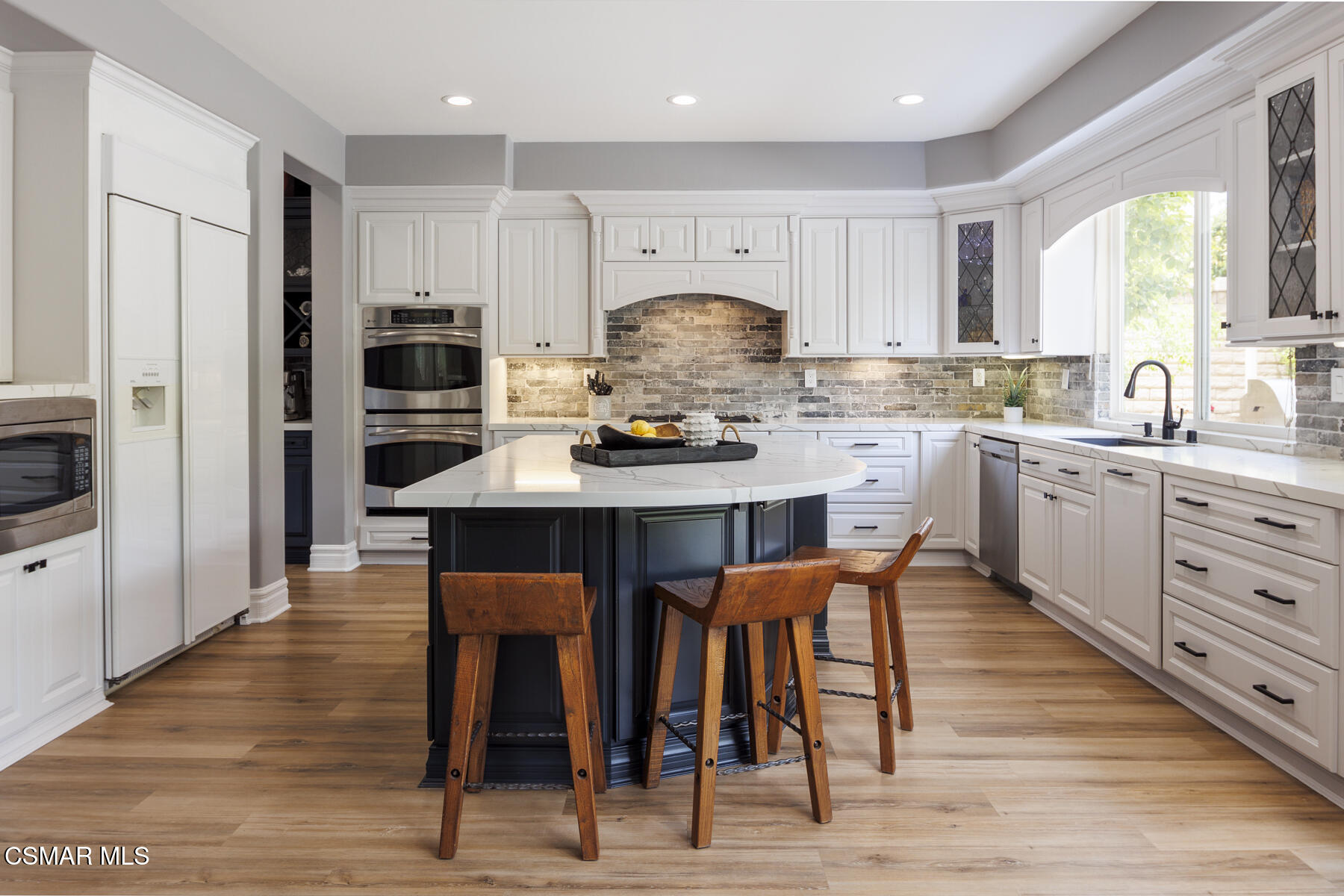 5859 Evening Sky Drive Simi Valley, CA 93063 - Photo 15 of 50 a kitchen with stainless steel appliances kitchen island granite countertop a table chairs sink refrigerator and cabinets