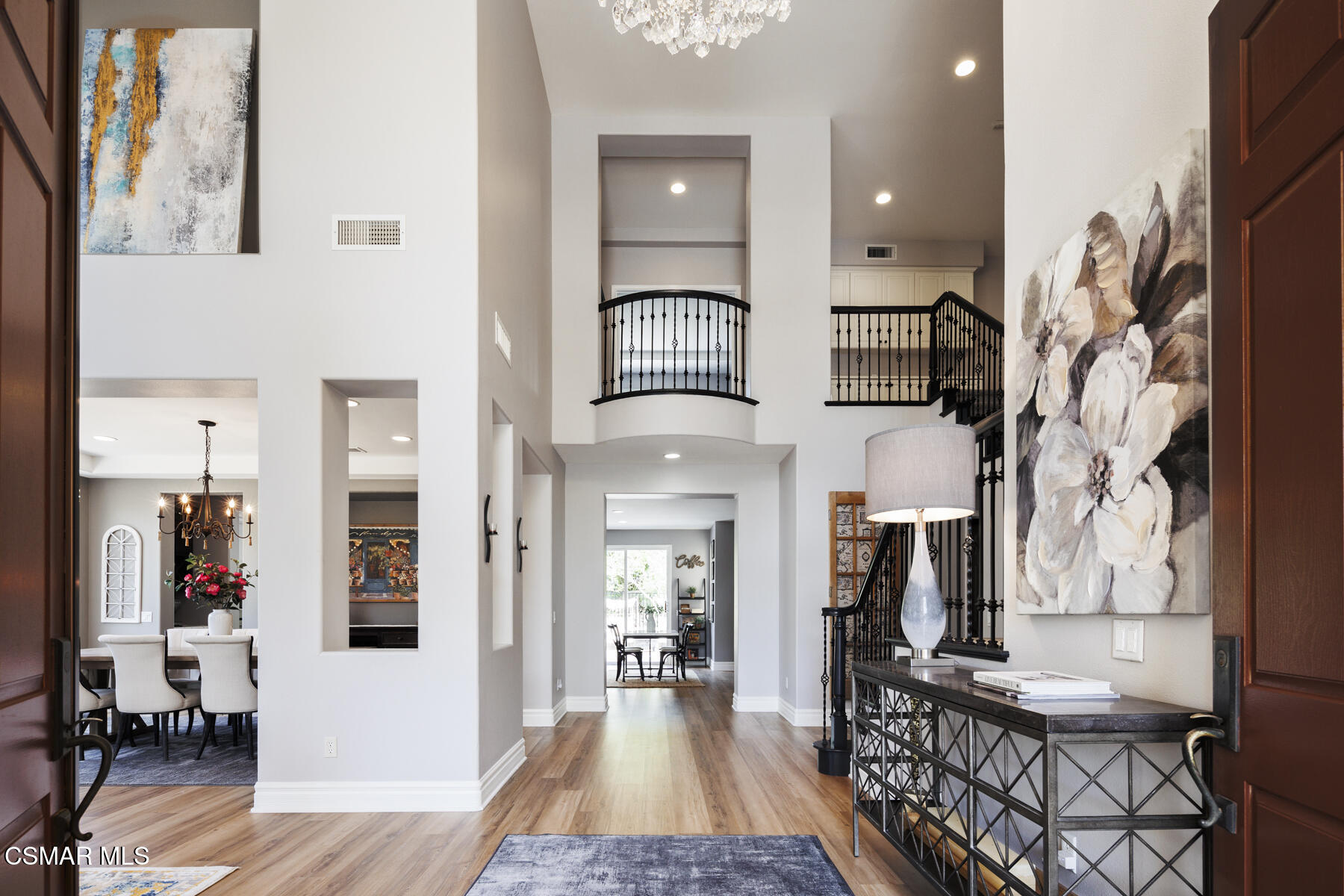 5859 Evening Sky Drive Simi Valley, CA 93063 - Photo 7 of 50 a view of a hallway to a livingroom with furniture wooden floor windows and a chandelier