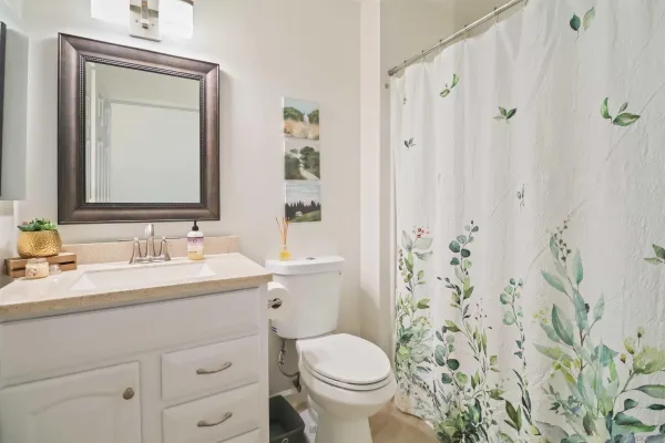 a bathroom with a granite countertop toilet sink and mirror