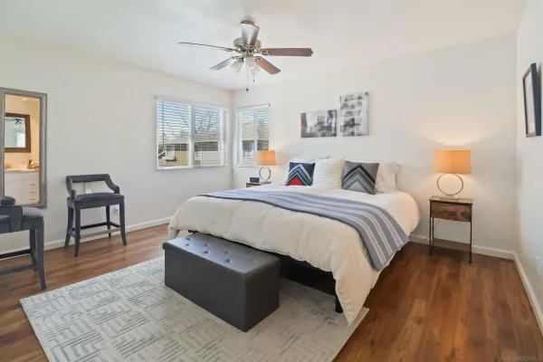 a spacious bedroom with a bed a table and chair