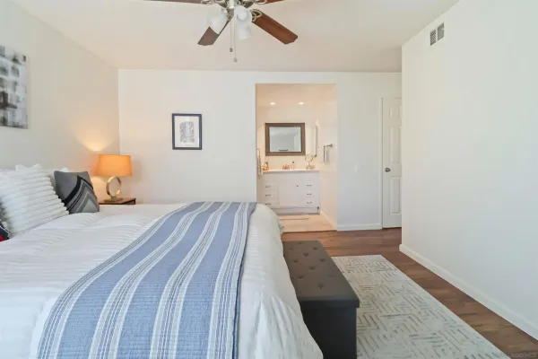 a bedroom with a bed and painting on the wall