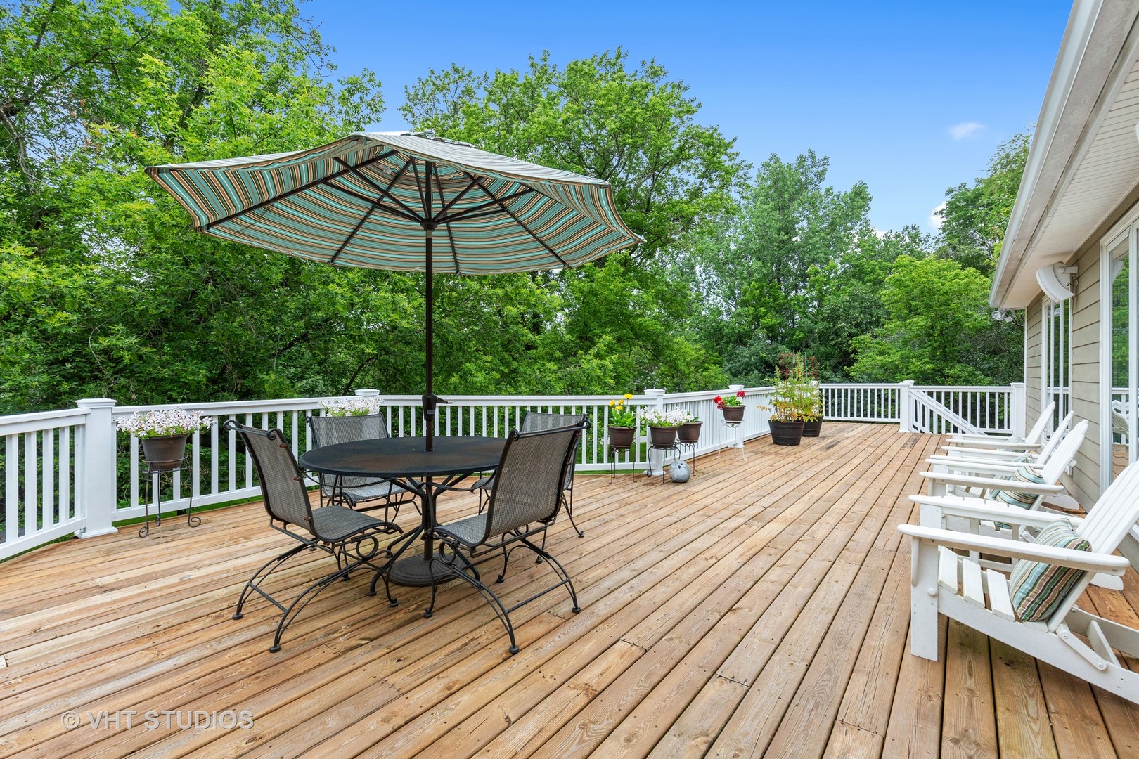 25287 Wren Road Tower Lakes, IL 60010 - Photo 32 of 51 a wooden deck with a table and chairs under an umbrella with wooden floor and fence