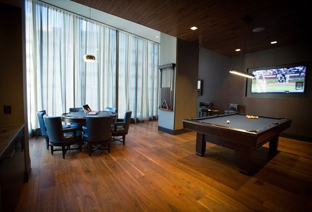 a living room with furniture a large window and wooden floor