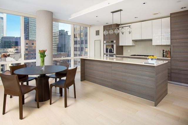 a kitchen with stainless steel appliances granite countertop a table chairs stove and wooden cabinets