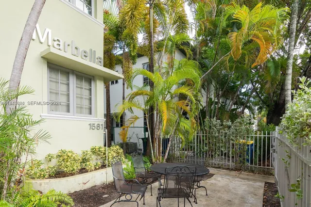 a view of a patio with table and chairs and potted plants