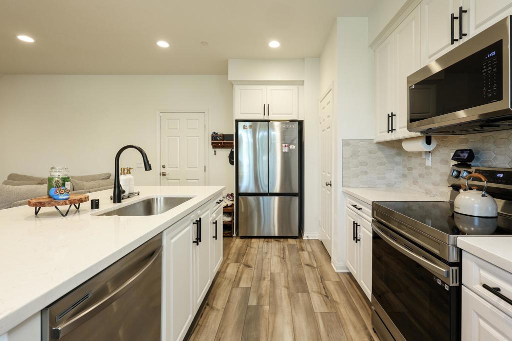 10443 Graphite Street Spring Valley, CA 91977 - Photo 11 of 18 a kitchen with stainless steel appliances a sink a stove and a refrigerator