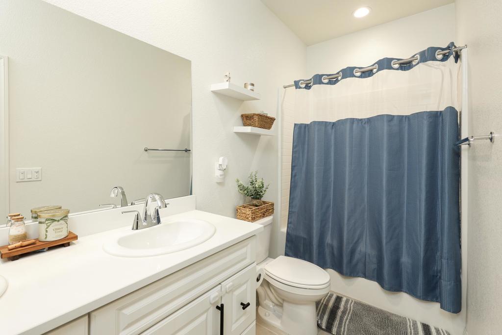 10443 Graphite Street Spring Valley, CA 91977 - Photo 9 of 18 a bathroom with a sink a toilet a mirror and shower curtain
