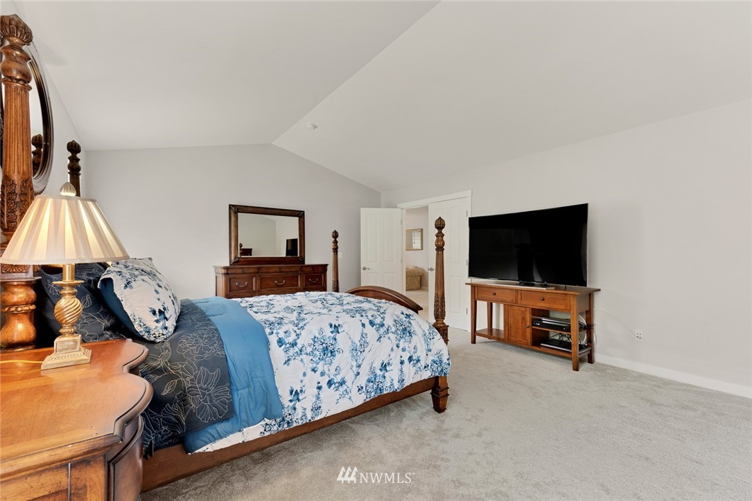 21909 39th Drive Southeast Bothell, WA 98021 - Photo 17 of 26 a bedroom with a bed and a flat tv screen on wall