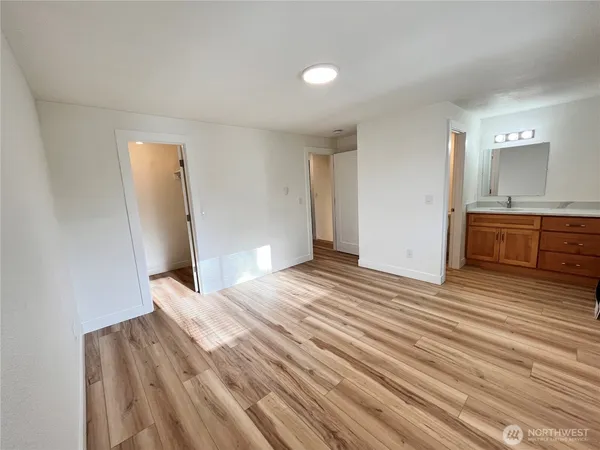 a view of empty room with wooden floor