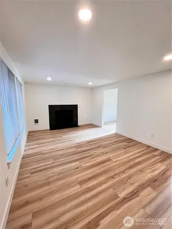 a view of empty room with wooden floor