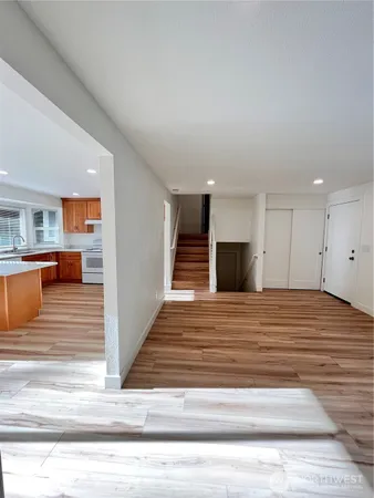 a view of a hallway with wooden floor and fireplace