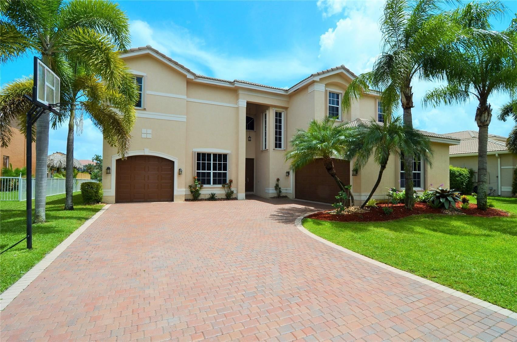 18602 Southwest 49th Street Miramar, FL 33029 - Photo 1 of 29 a front view of a house with a yard and palm trees