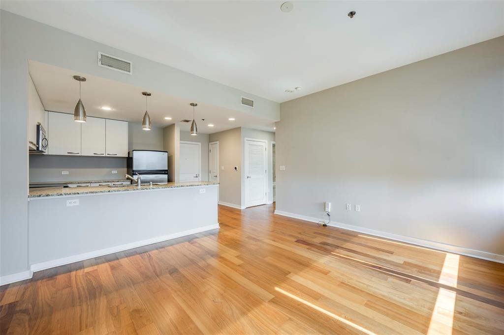 1200 Main Street, Unit 1002 Dallas, TX 75202 - Photo 12 of 30 a view of kitchen with kitchen island a sink wooden floor and stainless steel appliances