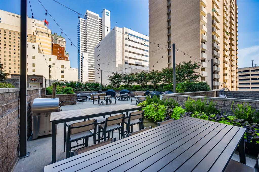 1200 Main Street, Unit 1002 Dallas, TX 75202 - Photo 28 of 30 a view of a roof deck with table and chairs a barbeque with wooden floor and fence
