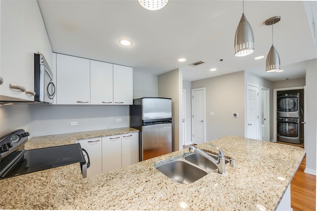 1200 Main Street, Unit 1002 Dallas, TX 75202 - Photo 5 of 30 a kitchen with stainless steel appliances granite countertop a sink refrigerator and cabinets
