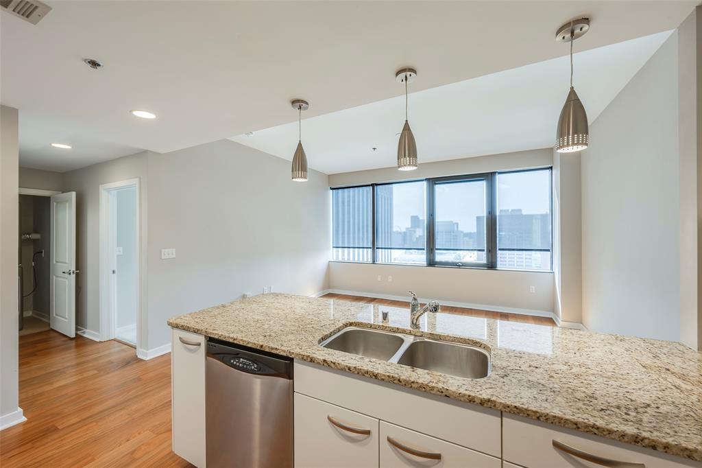 1200 Main Street, Unit 1002 Dallas, TX 75202 - Photo 6 of 30 a kitchen with a sink and a wooden floor