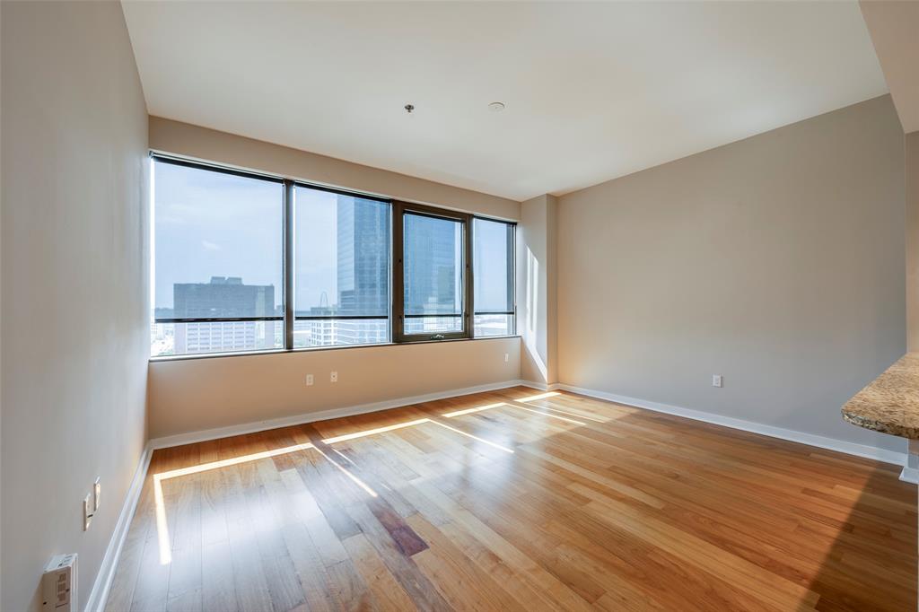 1200 Main Street, Unit 1002 Dallas, TX 75202 - Photo 8 of 30 a view of an empty room with wooden floor and a window