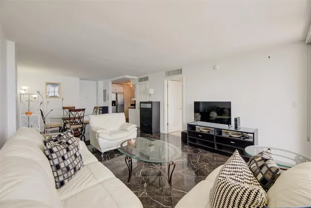 a living room with furniture a flat screen tv and a window